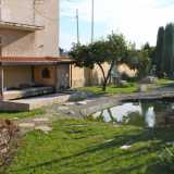Il giardino zen con ghiaia, un laghetto, lanterne in granito e il tipico espositore giapponese